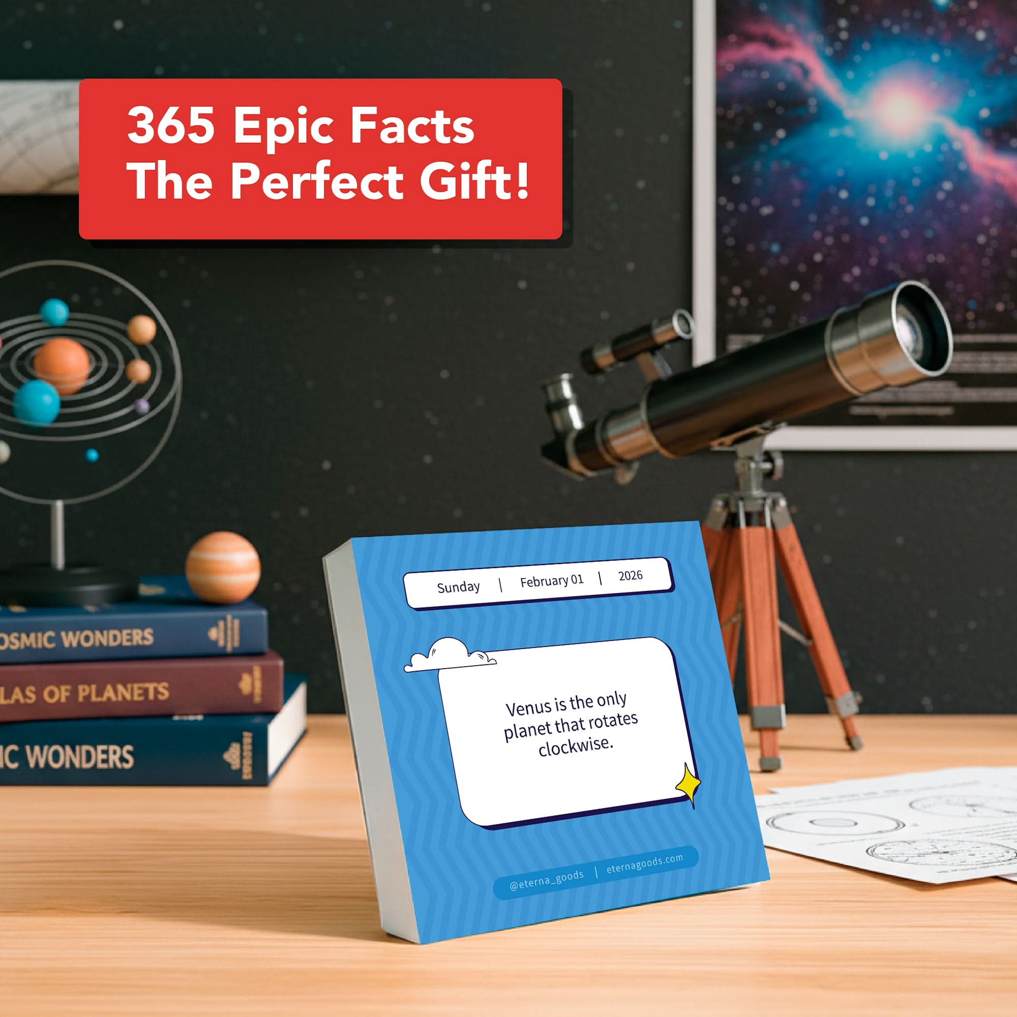 A desk features a telescope, astronomy books, and Eterna Goods’ 2026 Epic Facts Calendar showing a Venus fact; a sign states: “The perfect unique gift for fact lovers from Eterna Goods!”.