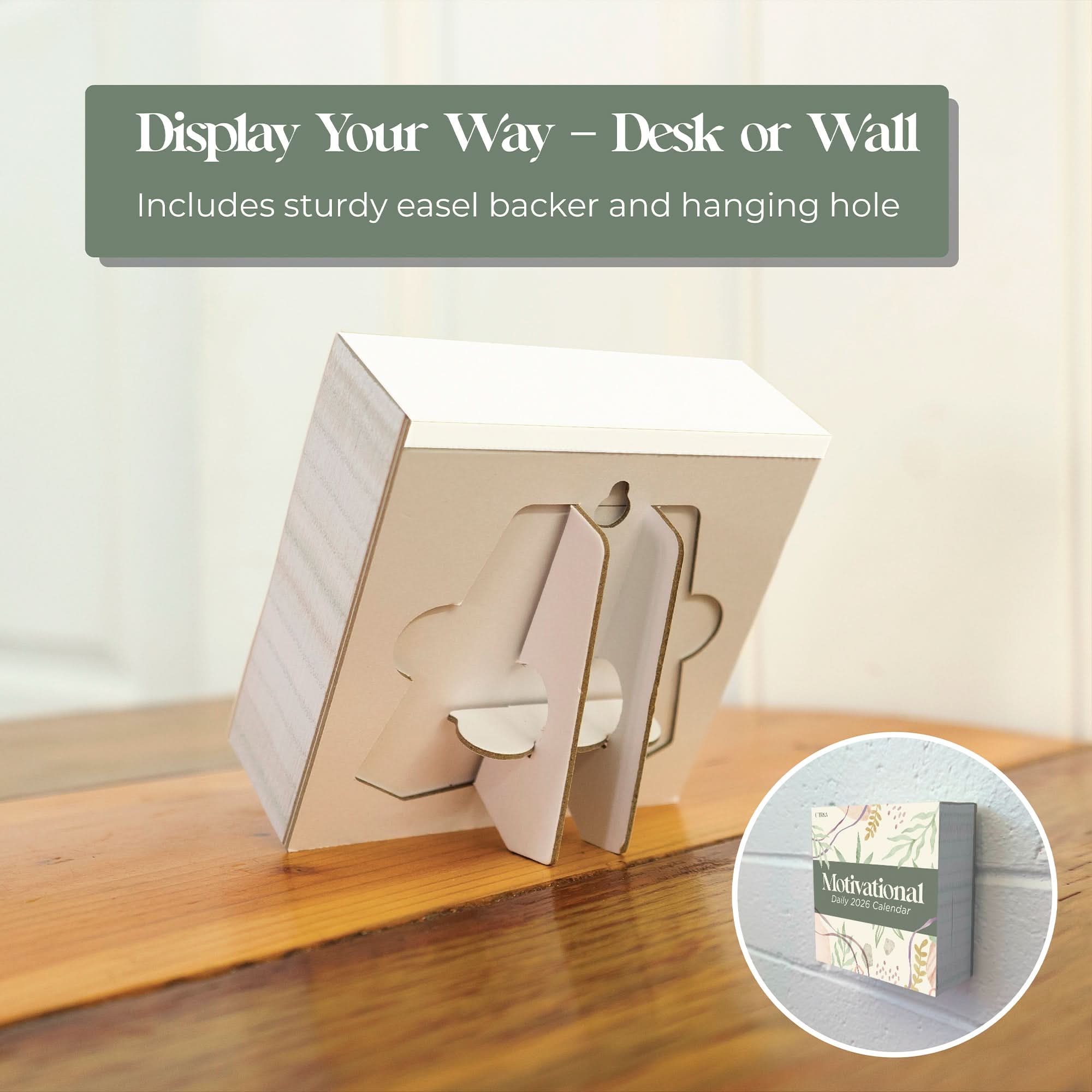 The Eterna Goods 2026 Motivational Calendar stands on a wooden surface with a sturdy easel backer; an inset shows it hanging on the wall, featuring daily motivational messages in a convenient tear-off desk calendar design.