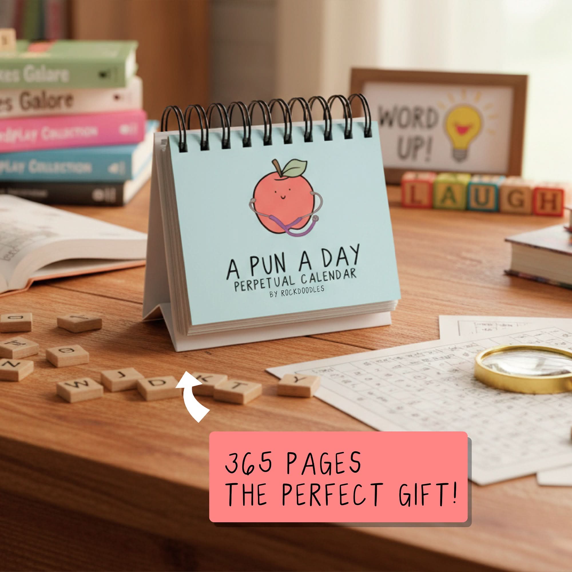 The "A Pun A Day Perpetual Calendar" by rockdoodles is a spiral-bound desk calendar, pictured with books and word games—a fun daily pun gift perfect for wordplay lovers.