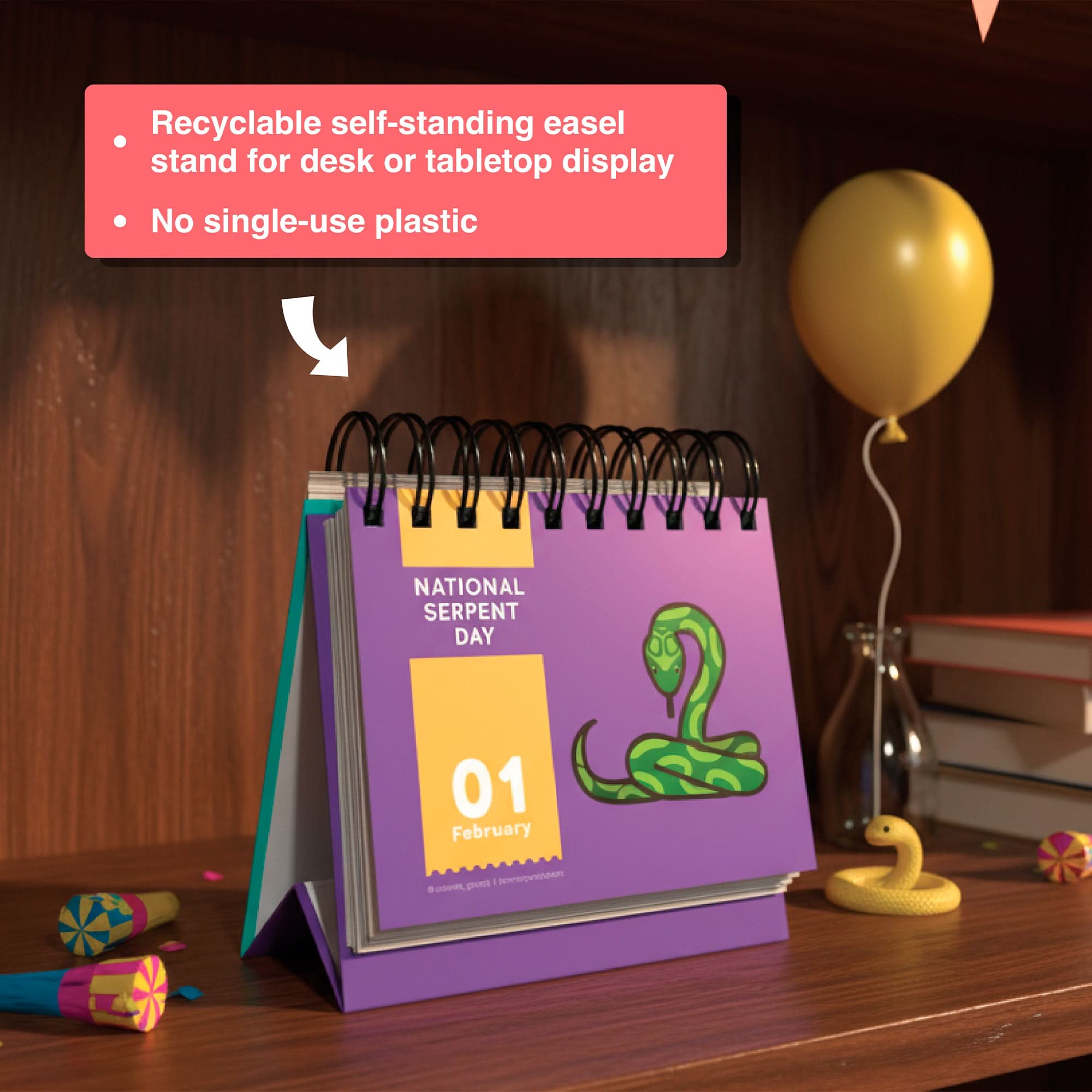 A Holiday Everyday Perpetual Calendar by Eterna Goods, open to February 1st for "National Serpent Day" with a snake illustration, sits on a wooden shelf with party items—perfect for tracking unique holidays year-round.