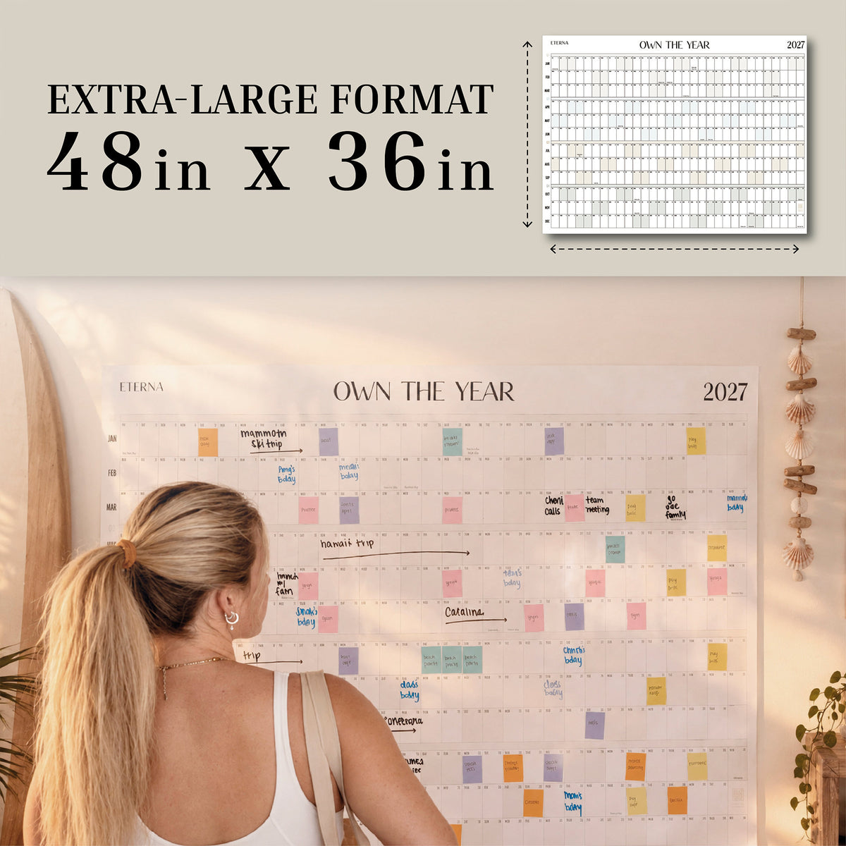Dated Own The Year Calendar, 48 x 36 inches, on a wall with a woman planning
