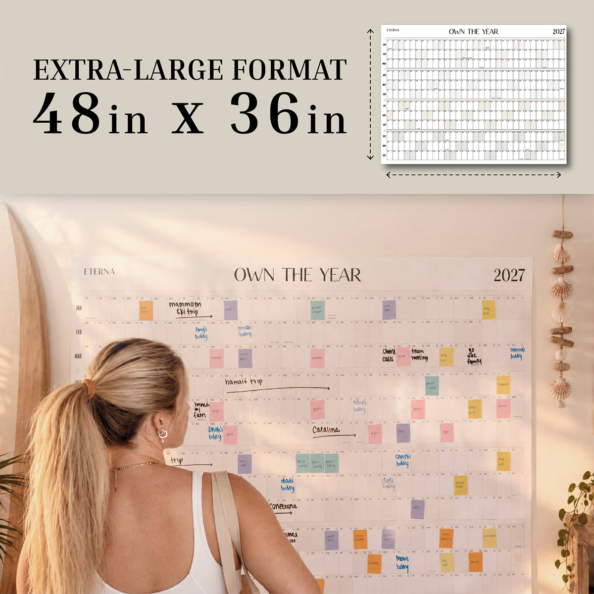 Dated Own The Year Calendar, 48 x 36 inches, on a wall with a woman planning