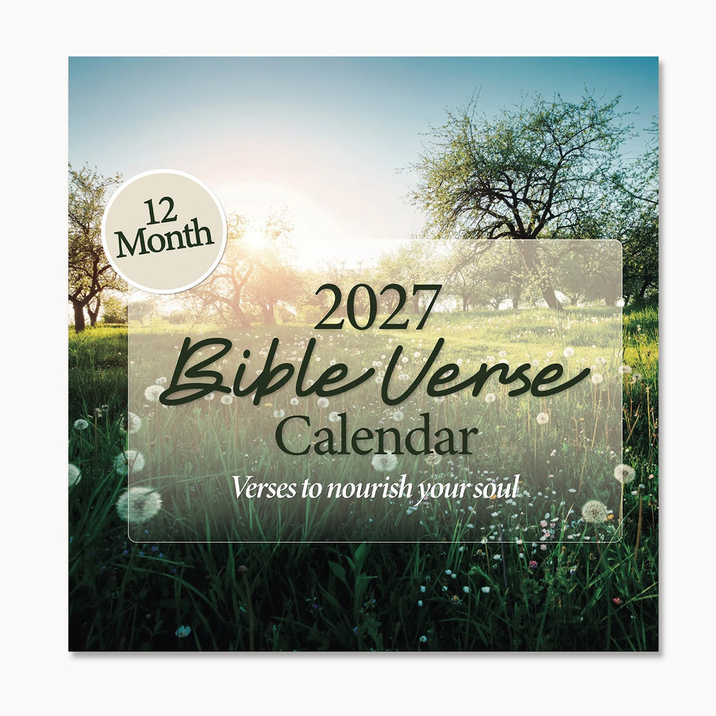 The 2027 Bible Verse Wall Calendar by Hannah Faith features a cover with a sunlit meadow and trees in the background. The front displays key text: "12 Month," "Christian Calendar," and "Verses to nourish your soul." This beautiful calendar filled with religious quotes is thoughtfully designed to inspire you throughout the year.