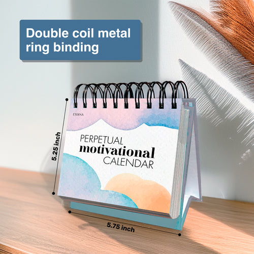 The Eterna Goods Motivational Perpetual Calendar with double coil metal binding is shown on a wooden surface. It measures 5.25" x 5.75".