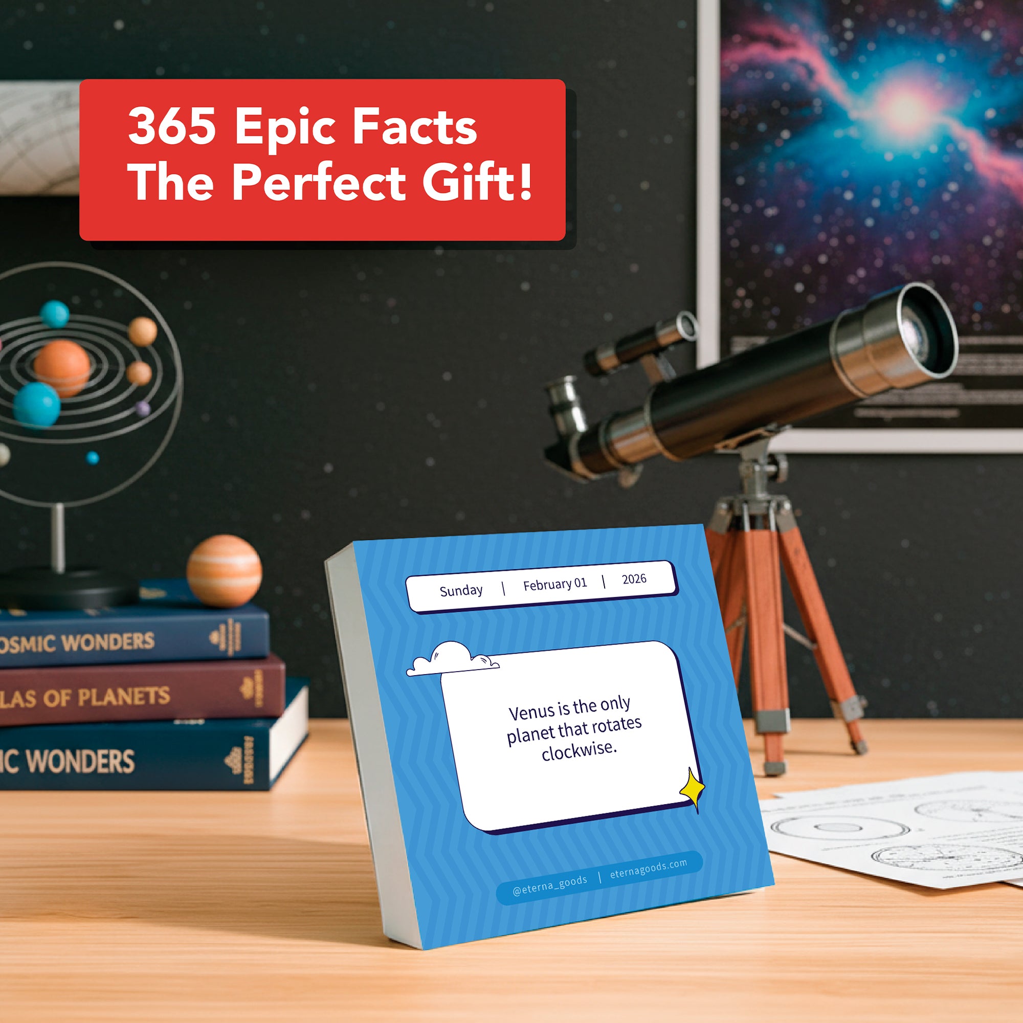 A desk features a telescope, astronomy books, and Eterna Goods’ 2026 Epic Facts Calendar showing a Venus fact; a sign states: “The perfect unique gift for fact lovers from Eterna Goods!”.