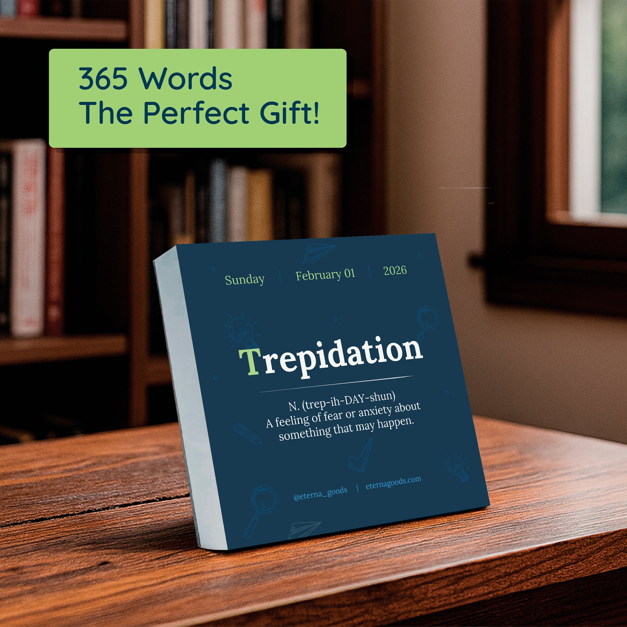 The Eterna Goods 2026 Word Of The Day Calendar sits on a wooden table in front of bookshelves, showing "Trepidation" with its definition for Sunday, February 1—a great gift for word lovers and language enthusiasts.