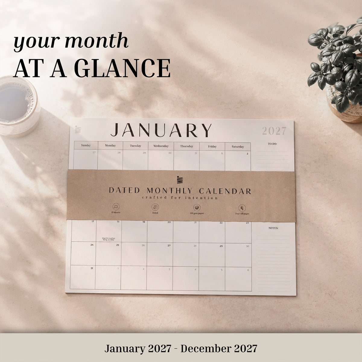 2027 flat desk calendar with its kraft band on a desk, labeled January 2027 to December 2027