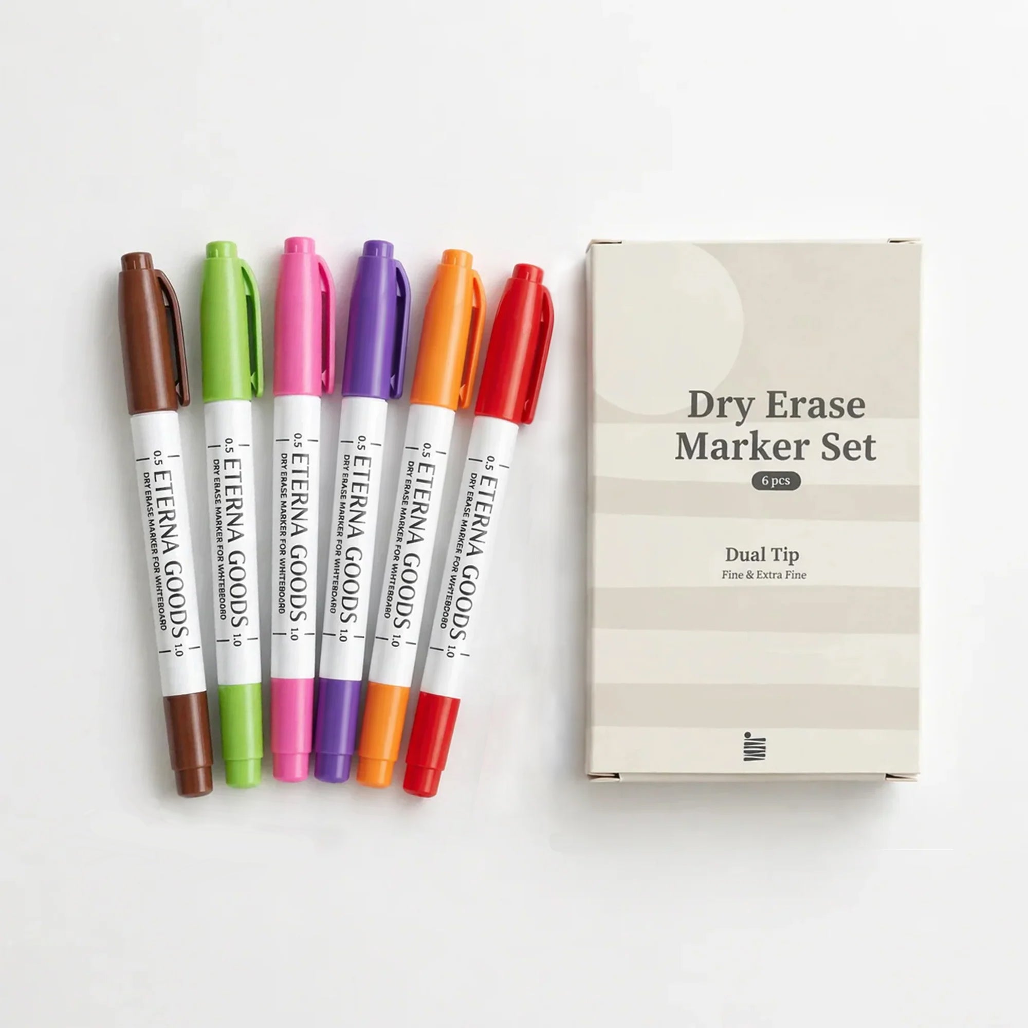 Six fine tip dry erase markers by Eterna Goods (brown, green, purple, pink, orange, red) are lined up beside a box labeled "Fine Tip Dry Erase Marker Set"—perfect for colorful writing and easy erasing.