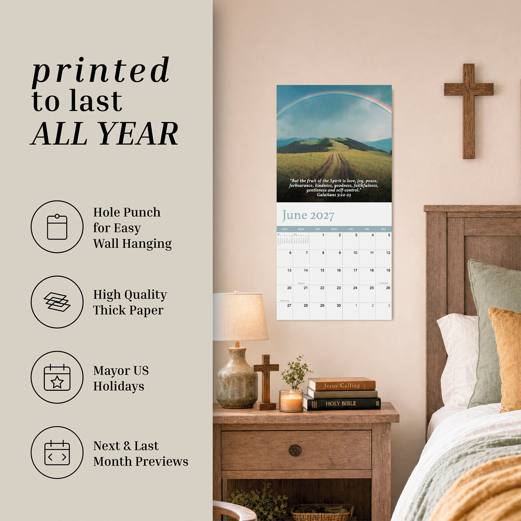 A 2027 Bible Verse Wall Calendar by Hannah Faith hangs above a wooden nightstand with a lamp and books in a cozy bedroom. Key features of this Christian calendar are highlighted on the left side of the image.