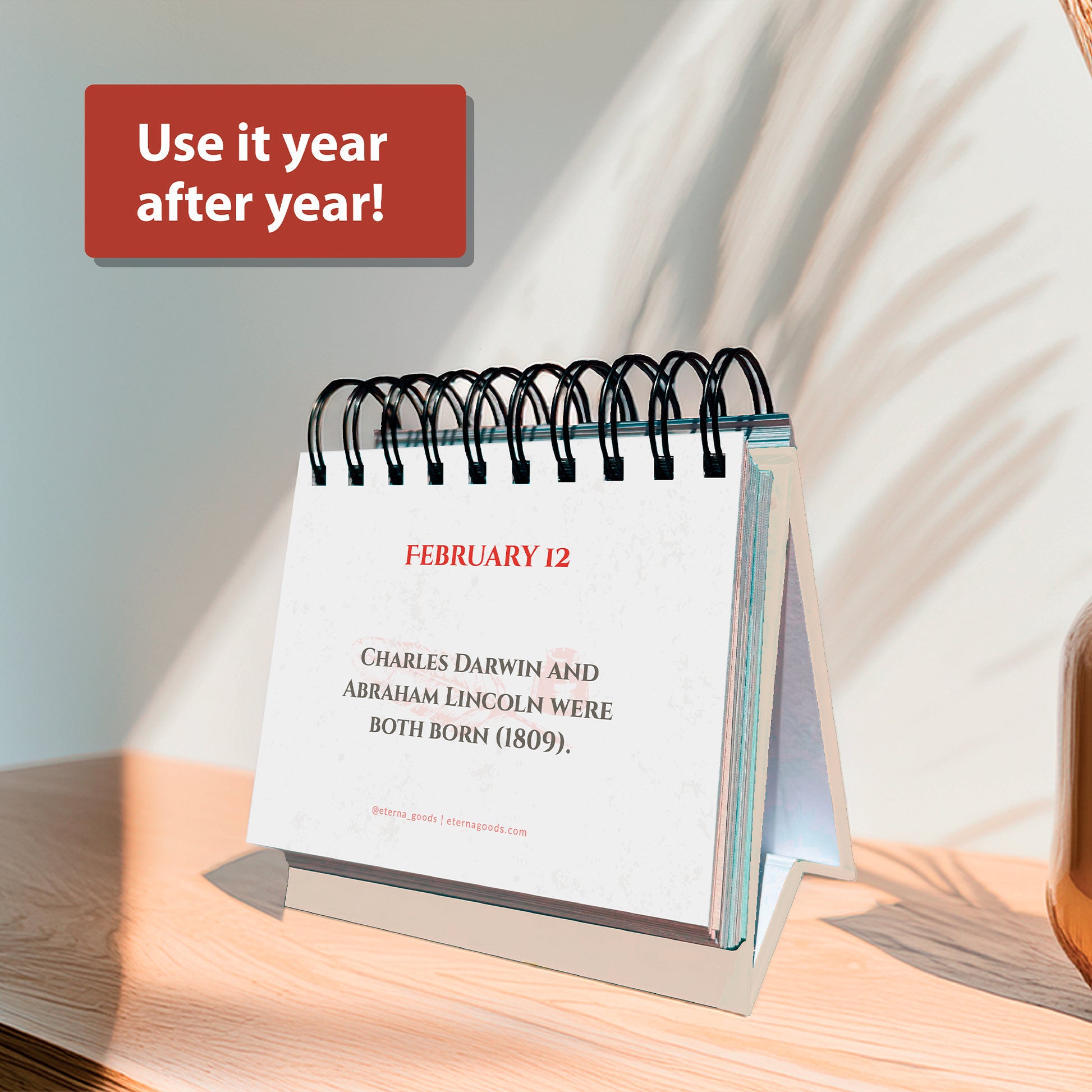 The Eterna Goods Today In History Perpetual Calendar, on a stand, highlights facts like Darwin and Lincoln’s shared birthday, with a sign above saying "Use it year after year!.