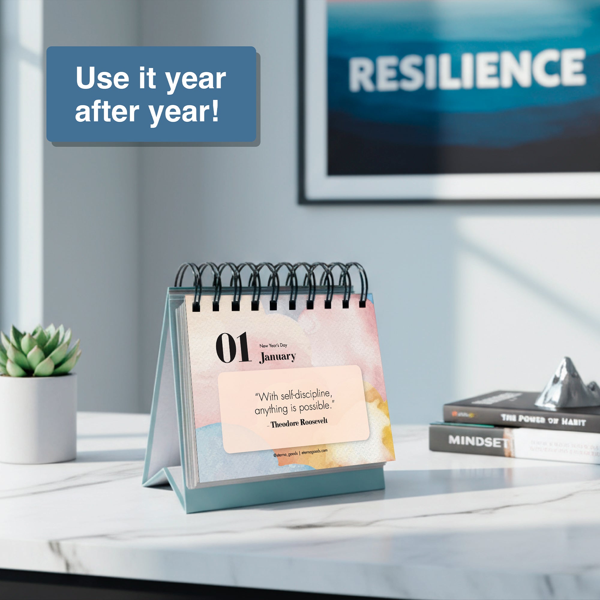 The Eterna Goods Motivational Perpetual Calendar sits on a table open to "01 January" with an inspiring quote, beside books titled "MINDSET" and "RESILIENCE." The box says, “Use it year after year!”.