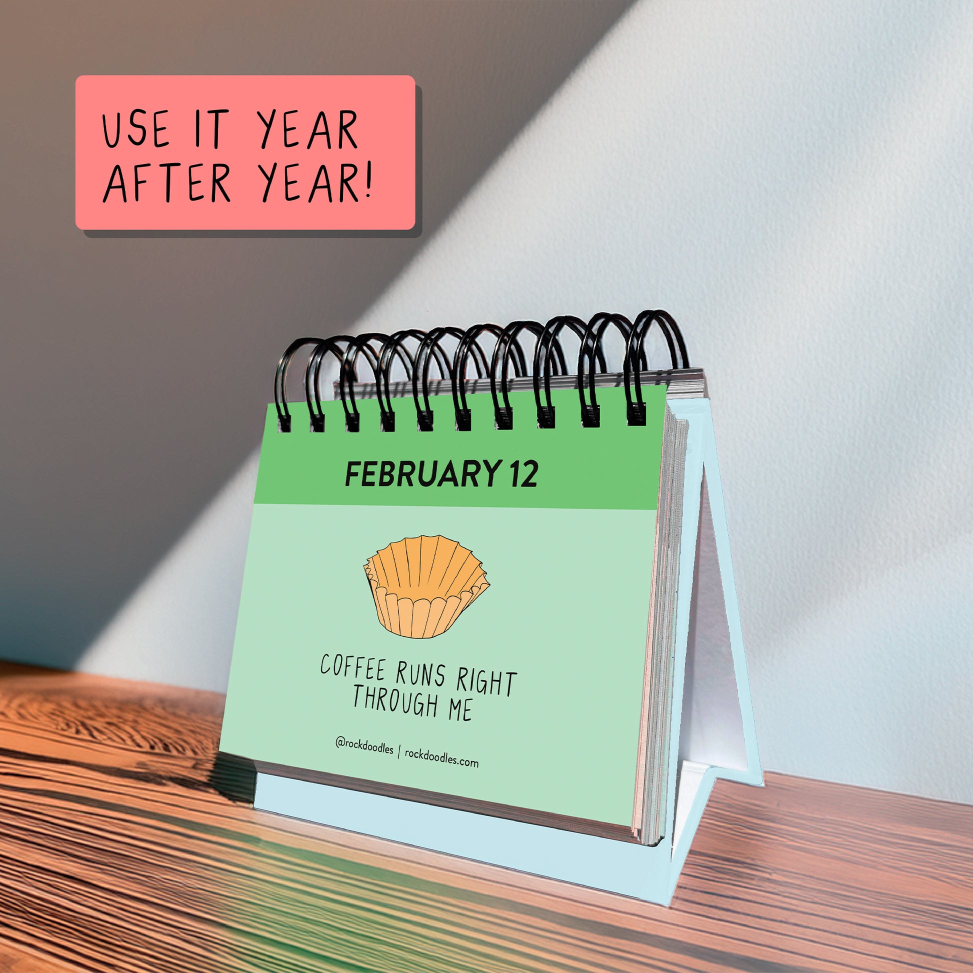 The A Pun A Day Perpetual Calendar by rockdoodles displays February 12 with a muffin illustration and the phrase "Coffee runs right through me." Use this fun desk calendar year after year!.