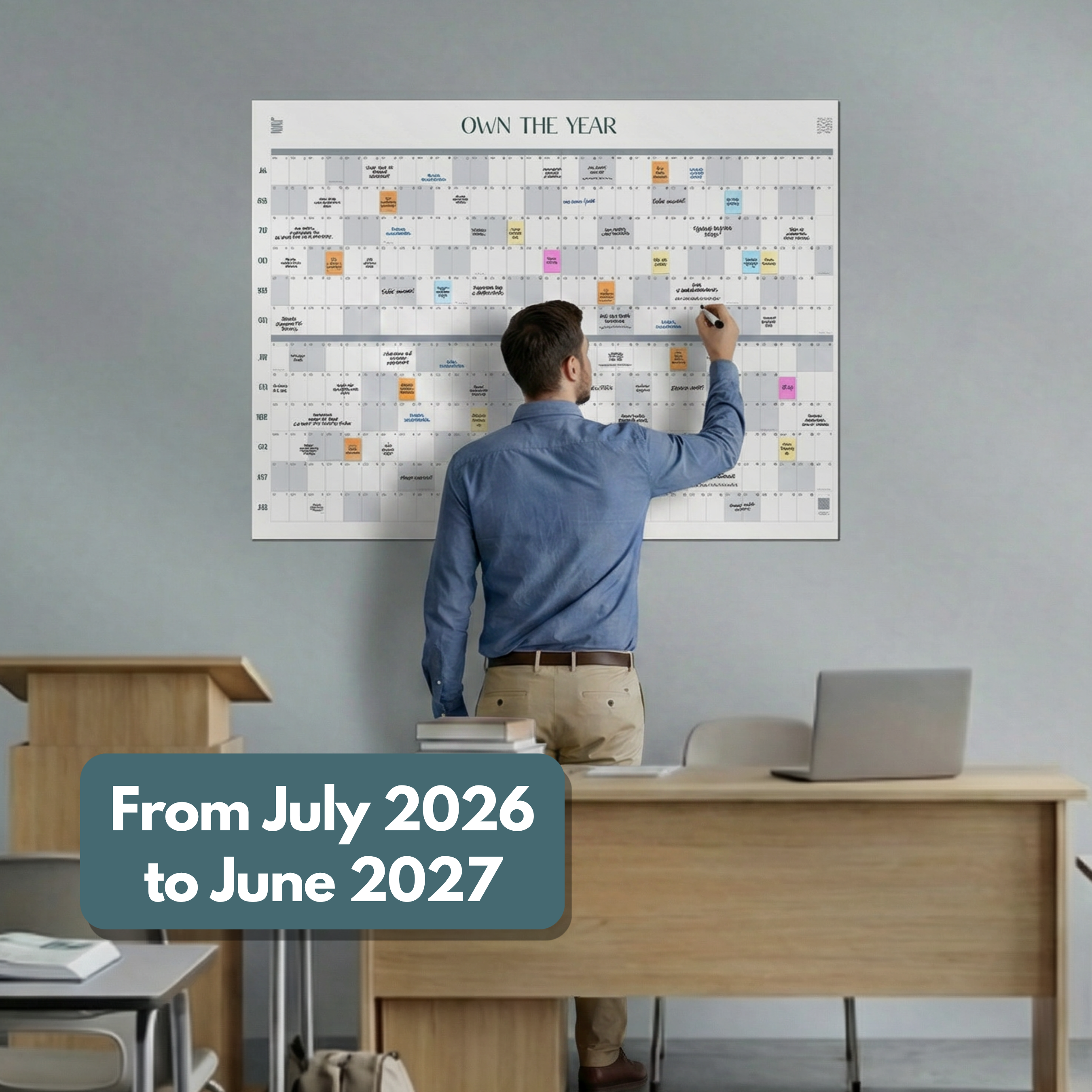 In an office, someone writes on the Eterna Goods Midyear/Academic Own the Year 2026-2027 GIANT Dry Erase Wall Calendar (4ft x 3ft), planning from July 2026 to June 2027 for intentional living.
