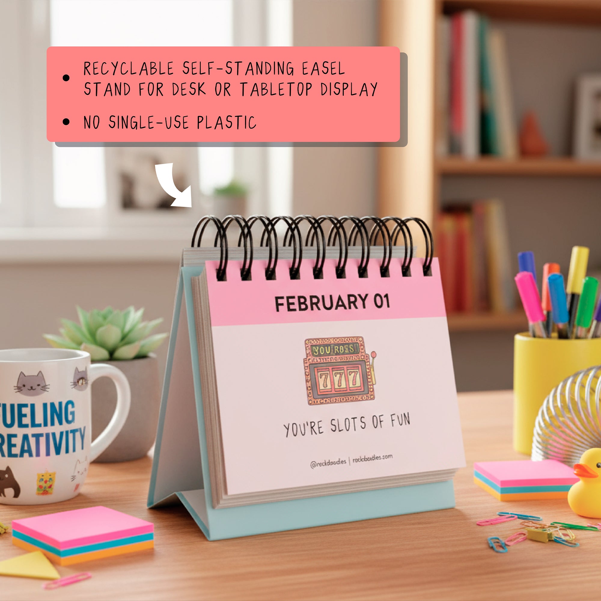 The rockdoodles A Pun A Day Perpetual Calendar sits on a desk with books, stationery, and a mug. Enjoy daily puns and eco-friendly design—recyclable easel, no single-use plastic. The perfect witty gift for any workspace!.