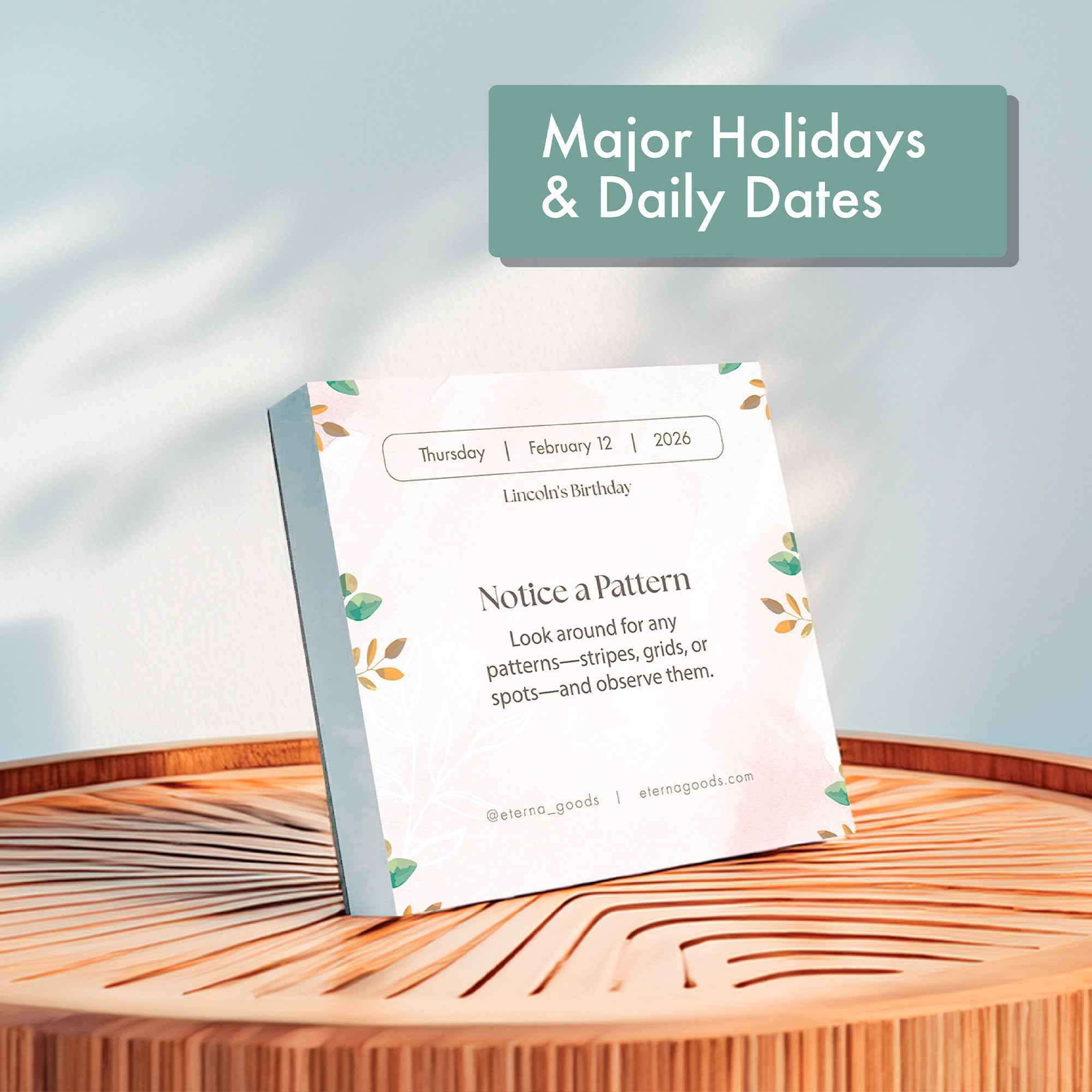 The Eterna Goods 2025 Mindfulness Calendar sits on a wooden surface in soft sunlight, open to Thursday, February 12—Lincoln’s Birthday—with a prompt to notice patterns.