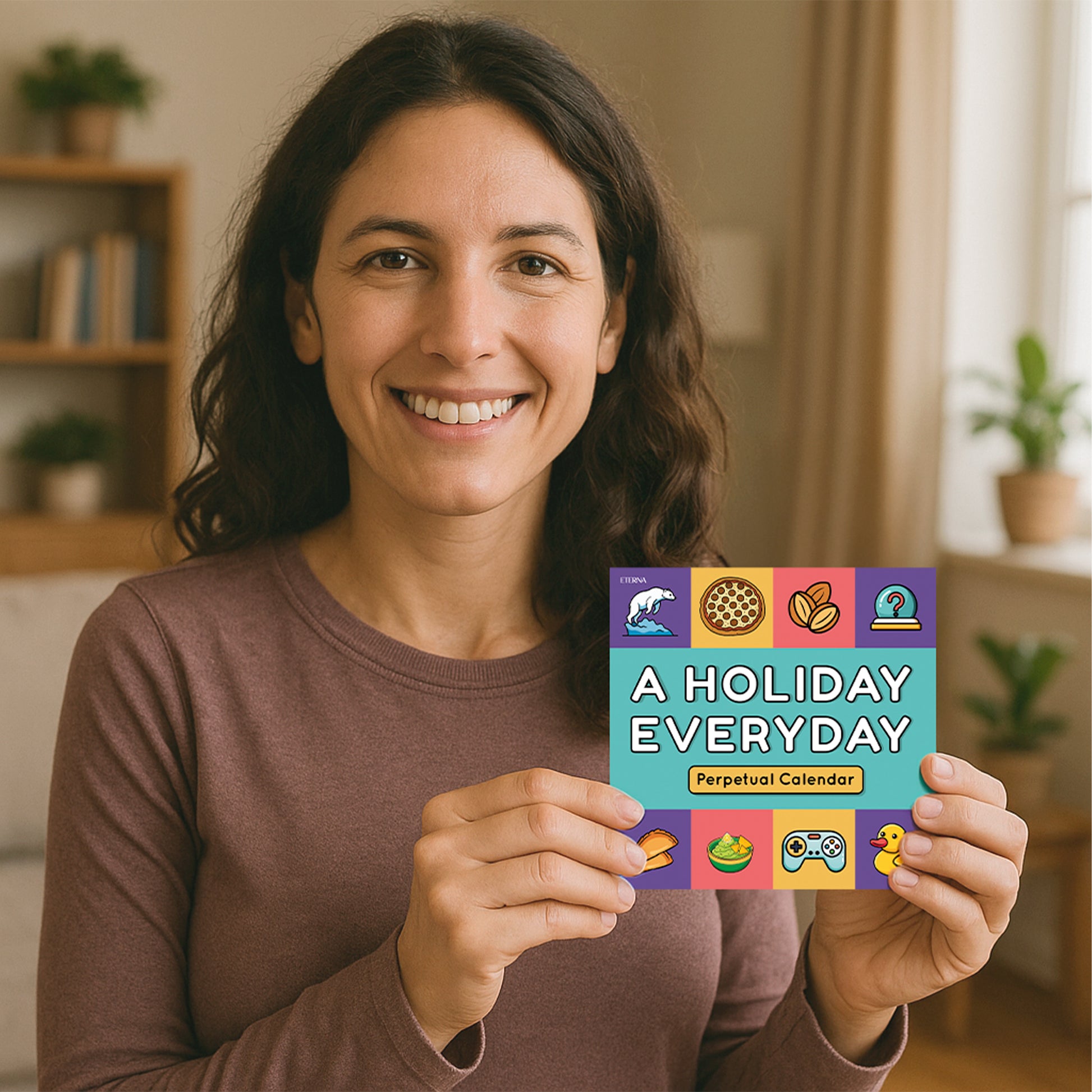 A woman smiles while holding the Eterna Goods "A Holiday Everyday Perpetual Calendar," with shelves and plants in the background.