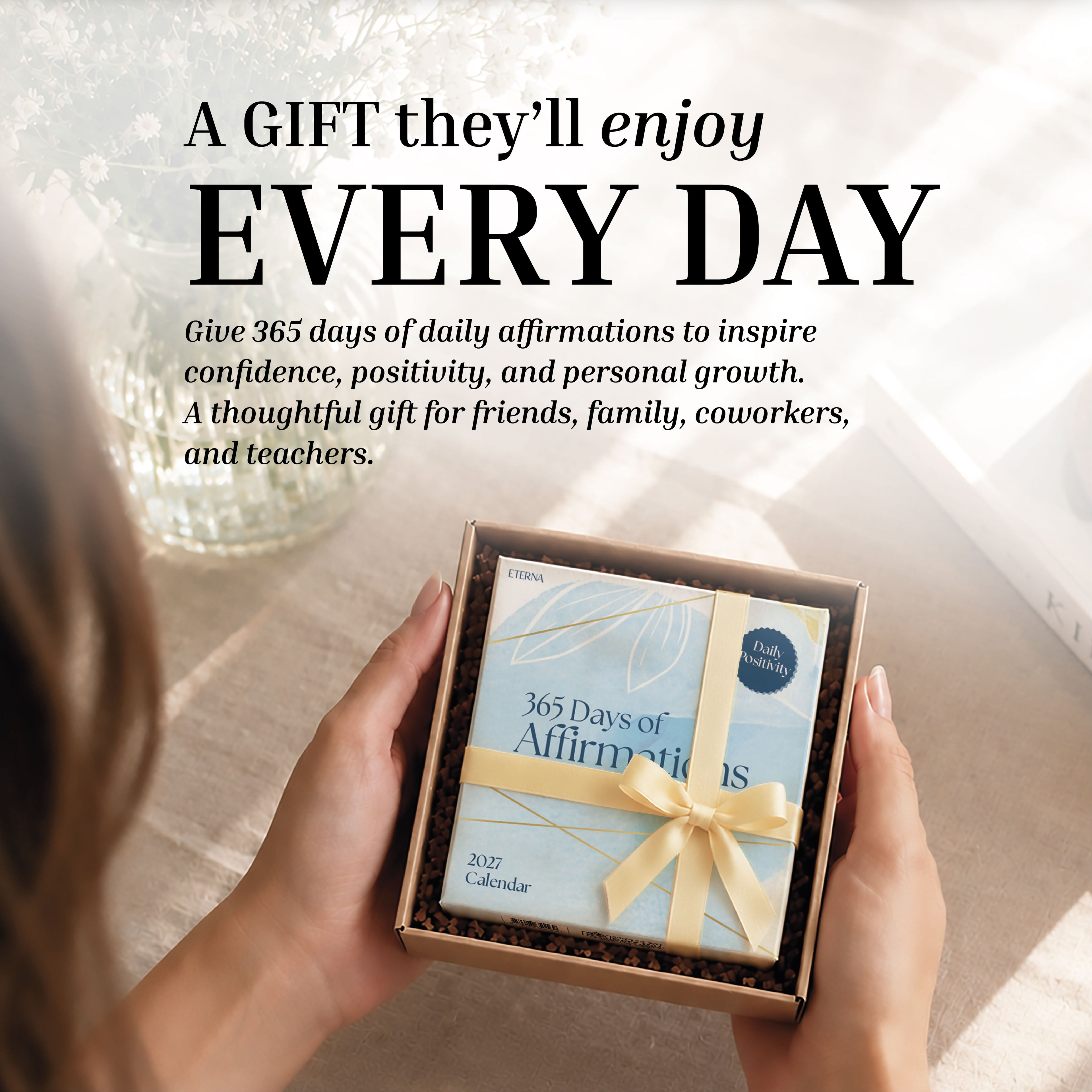 A person holds a boxed 2027 Daily Affirmations Calendar by Eterna Goods; surrounding text promotes this inspiring calendar as the perfect daily gift for confidence, mindfulness, and positivity through uplifting affirmations.