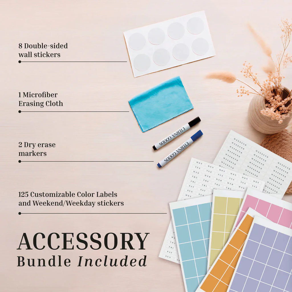 A bundle featuring the Own The Year Calendar by Eterna Goods, complete with wall stickers, a microfiber cloth, two dry erase markers, and customizable color labels with weekday stickers—ideal for setting up your academic wall planner or undated wall calendar—beautifully displayed on a light wooden surface.