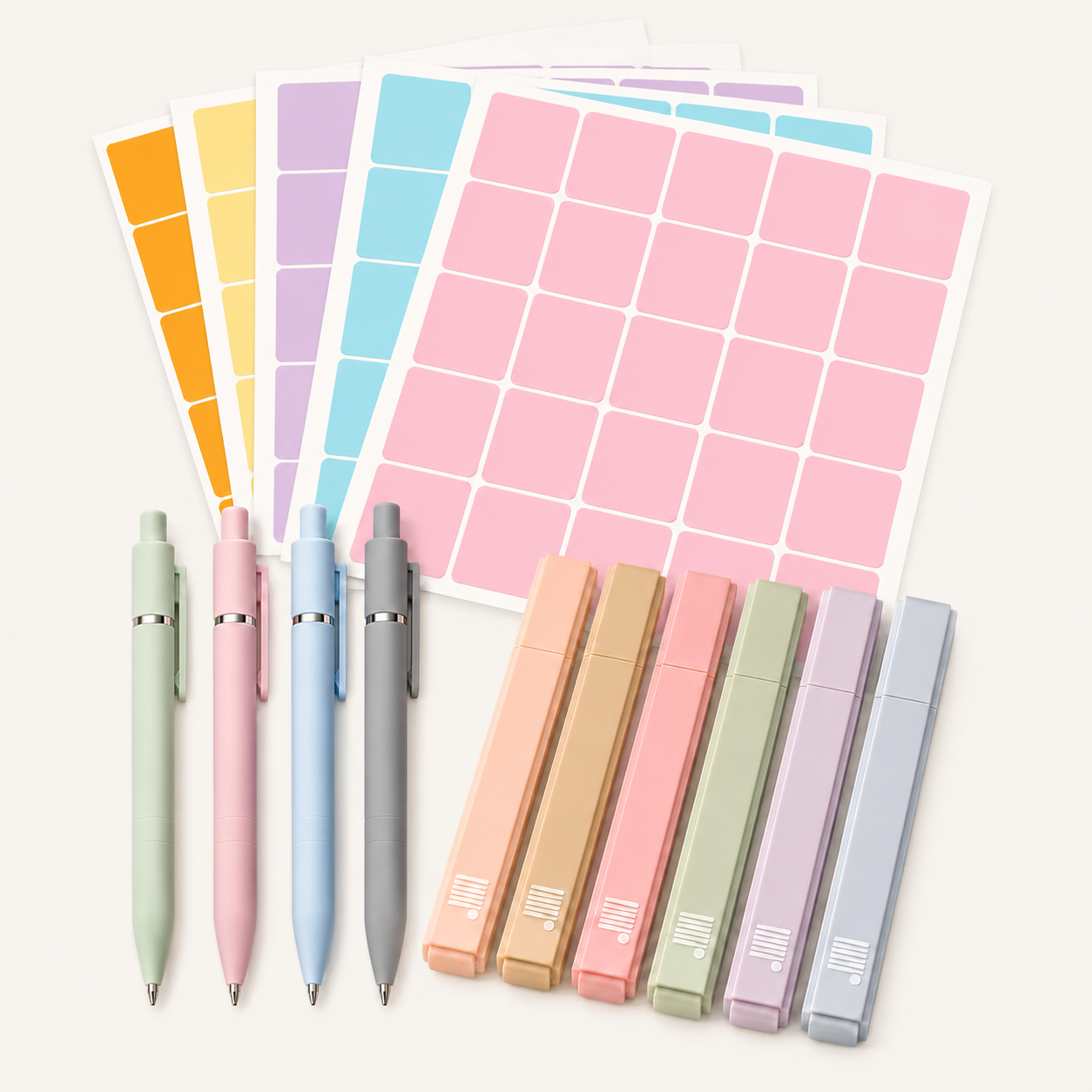 The Planning Essentials Kit by Eterna Goods features five fine-tip pens, five pastel highlighters, and four sheets of rectangular colored stickers—everything you need for perfect planning arranged on a light surface.