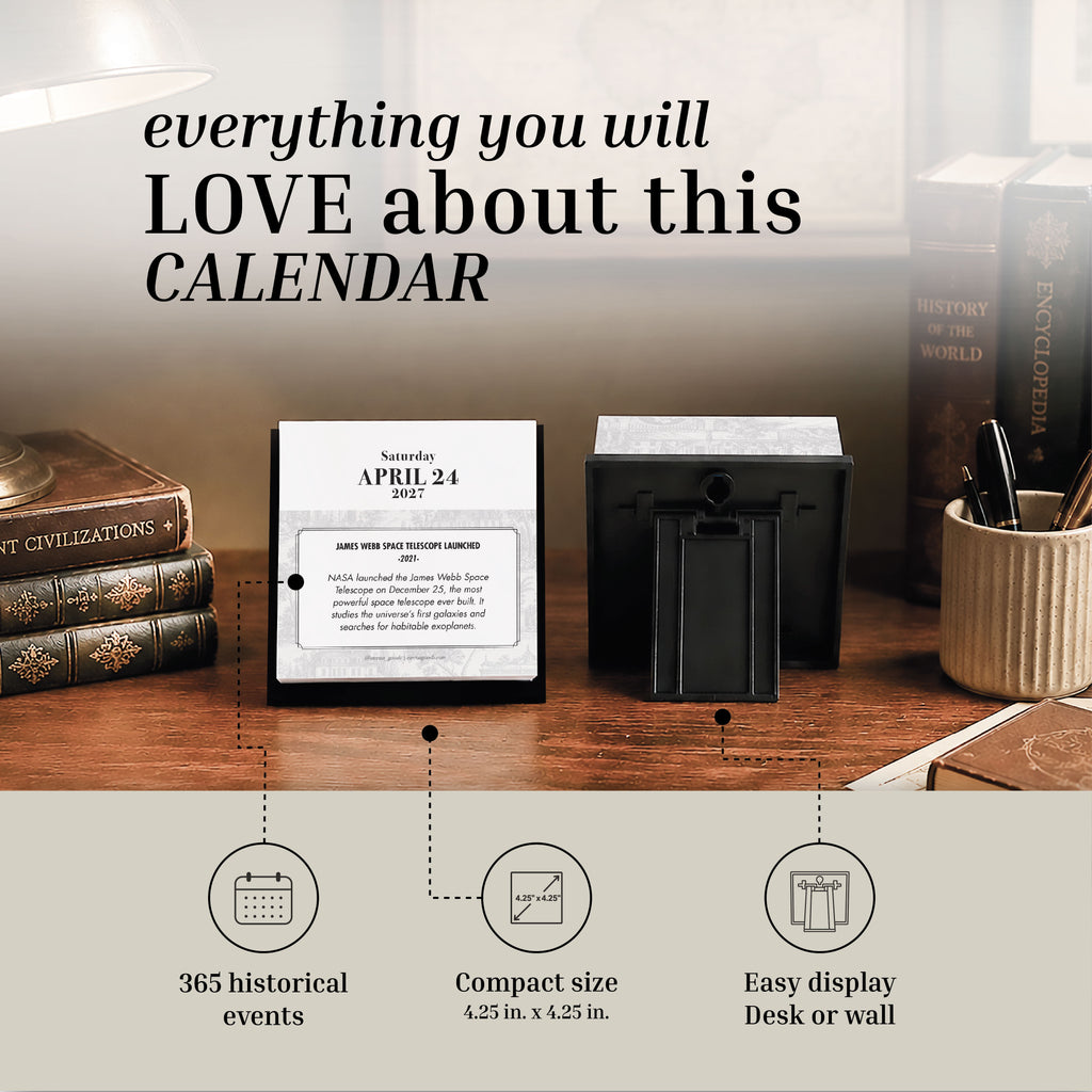 The Eterna Goods 2027 Historical Facts Calendar is an inspirational desk accessory showing April 24, featuring historical event text. It is placed on a wooden desk alongside books and a pen holder, with labeled features including 365 events, compact size, and easy-to-tear pages for effortless daily display.