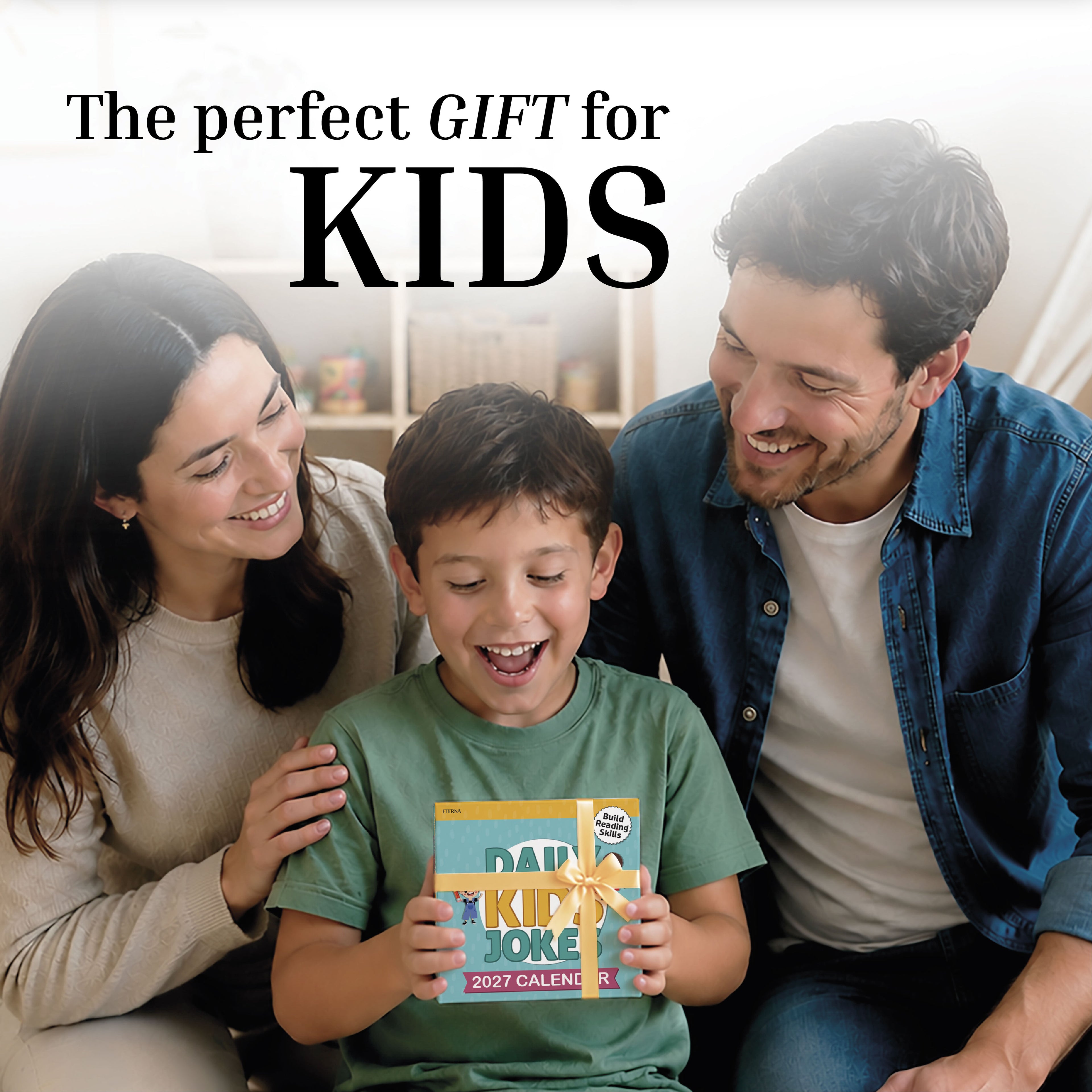 A smiling boy holds a "2027 Kids Jokes Calendar" by Charlie's Treasures while sitting between two adults on a couch. Text above reads, "The perfect gift for kids." This kid-friendly calendar from Charlie’s Treasures brings laughter to every day and is the ideal gift for children.