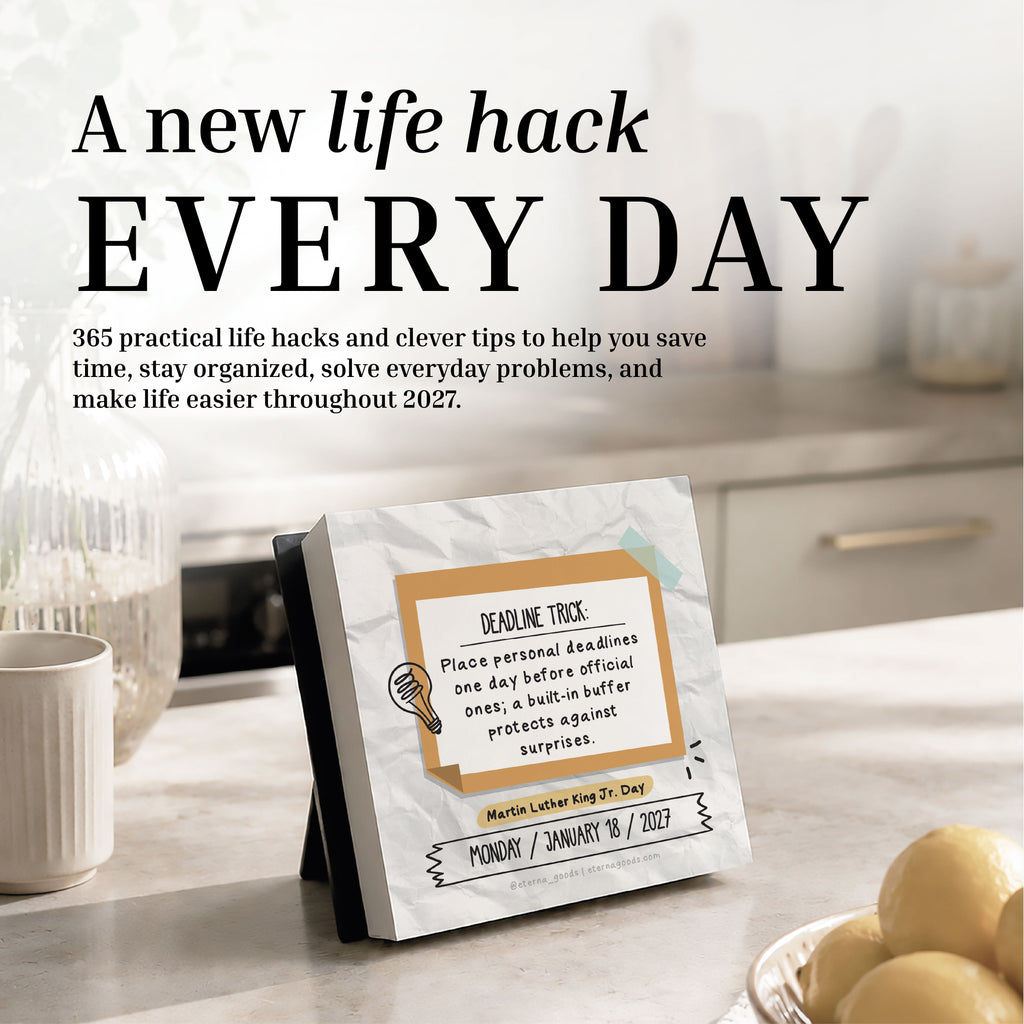 An Eterna Goods 2027 Daily Life Hacks Calendar featuring a tip on meeting deadlines is displayed on a table by a cozy seating area, with sunlight streaming through the window.