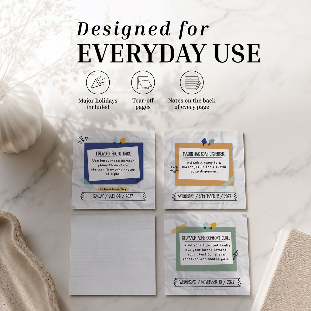 Three tear-off notepads from the Eterna Goods 2027 Daily Life Hacks Calendar rest on a marble surface; above them, text highlights features such as major holidays and notes included on the back of every page. Perfect for staying organized, this tear-off desk calendar also provides productivity tips inspired by the Daily Life Hacks series.