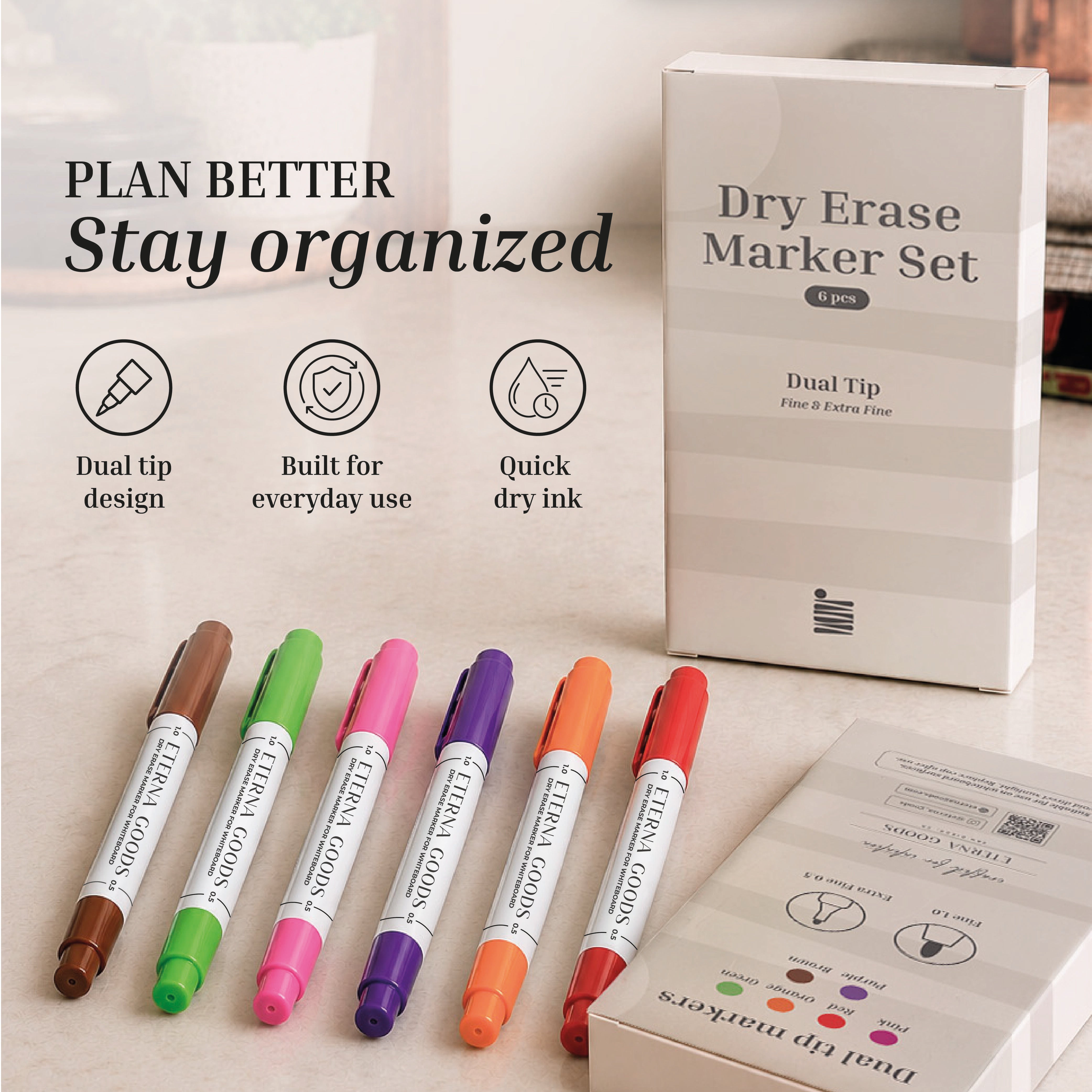The Eterna Goods Fine Tip Dry Erase Marker Set features six assorted colors displayed by their packaging, highlighting a quick-drying formula and fine tips for precise writing.