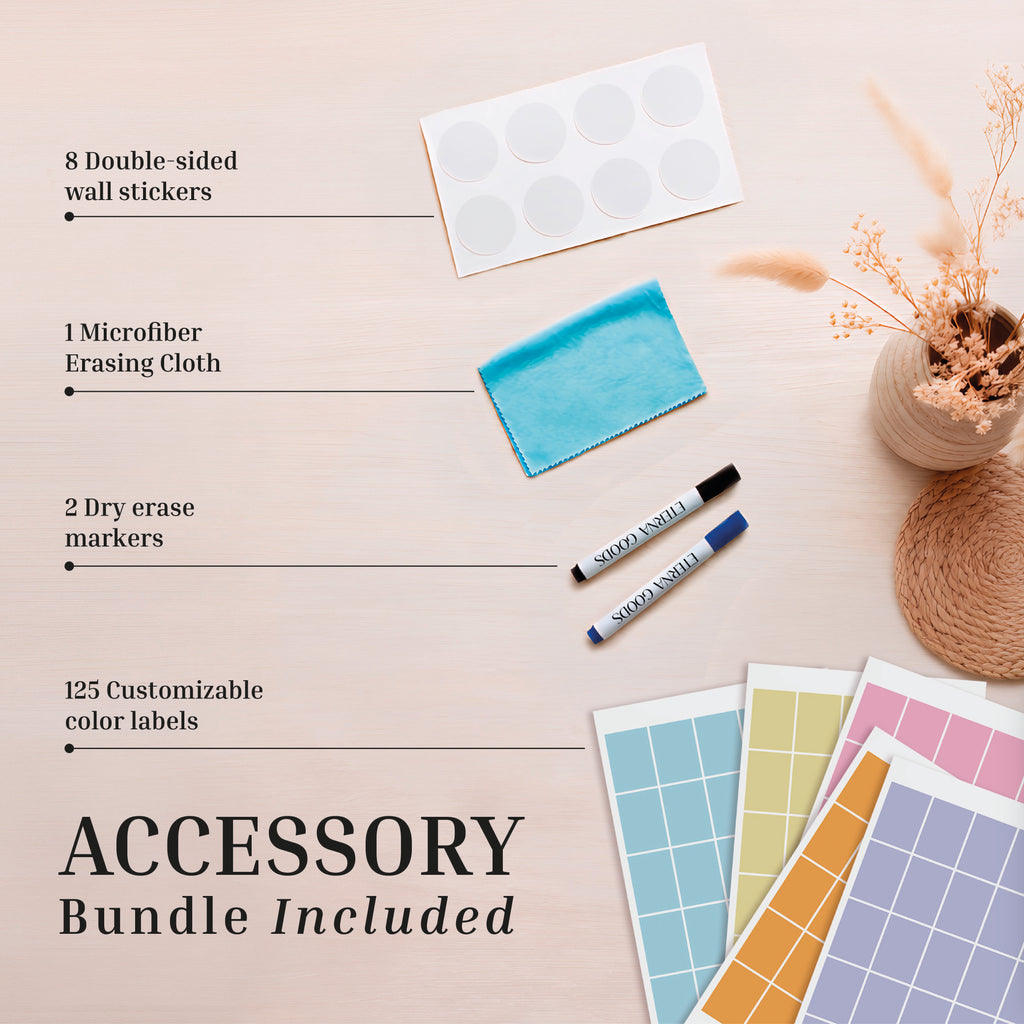 Flat lay of Eterna Goods’ 2026-2027 Midyear/Academic Own The Year Calendar accessory bundle: 8 wall stickers, blue microfiber cloth, 2 dry erase markers, and 125 color labels on a light wooden surface with dried flowers.