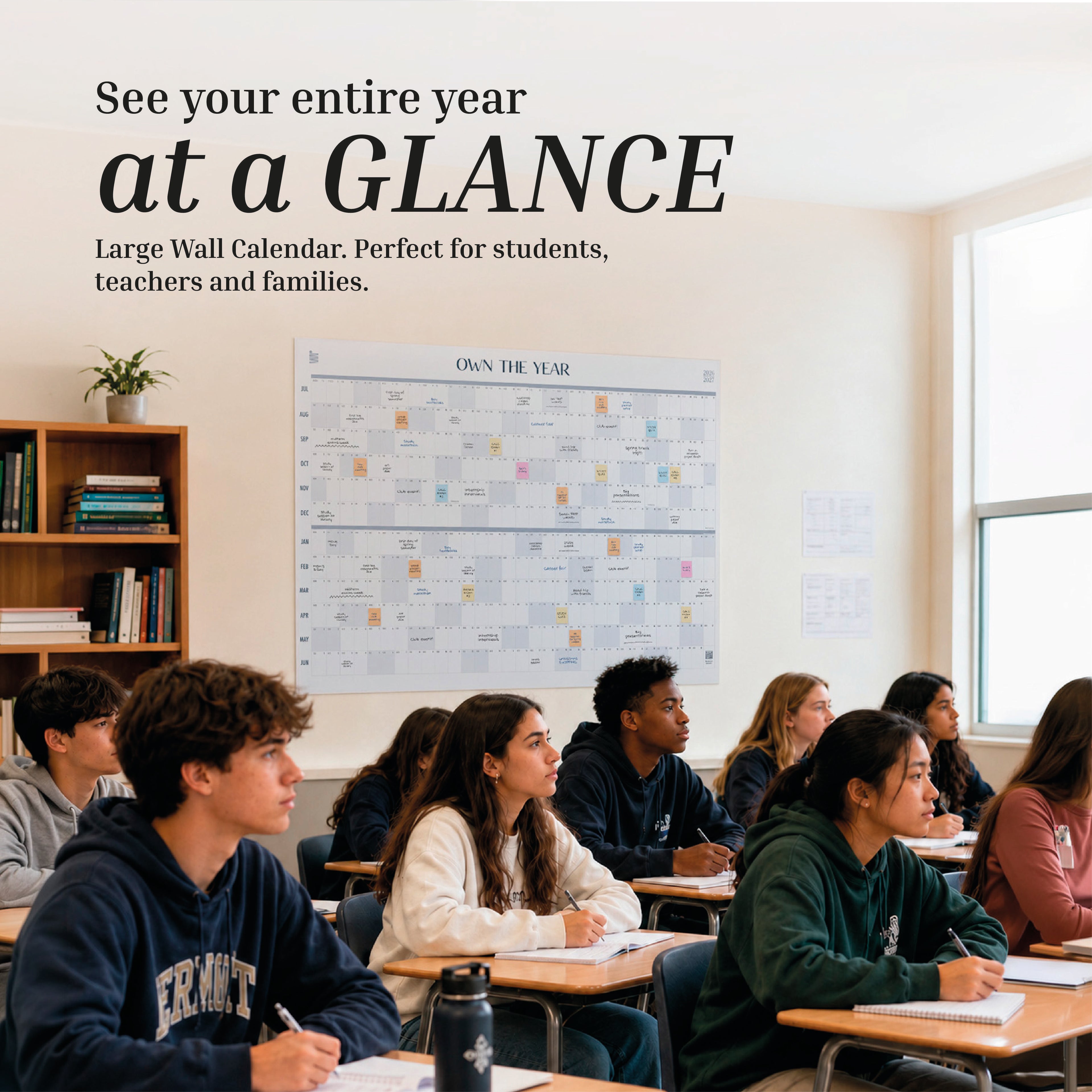 Students sit at desks in a classroom facing forward. Behind them, an Eterna Goods 2026-2027 Midyear/Academic Own The Year Calendar hangs on the wall, with shelves holding books and plants also in view.