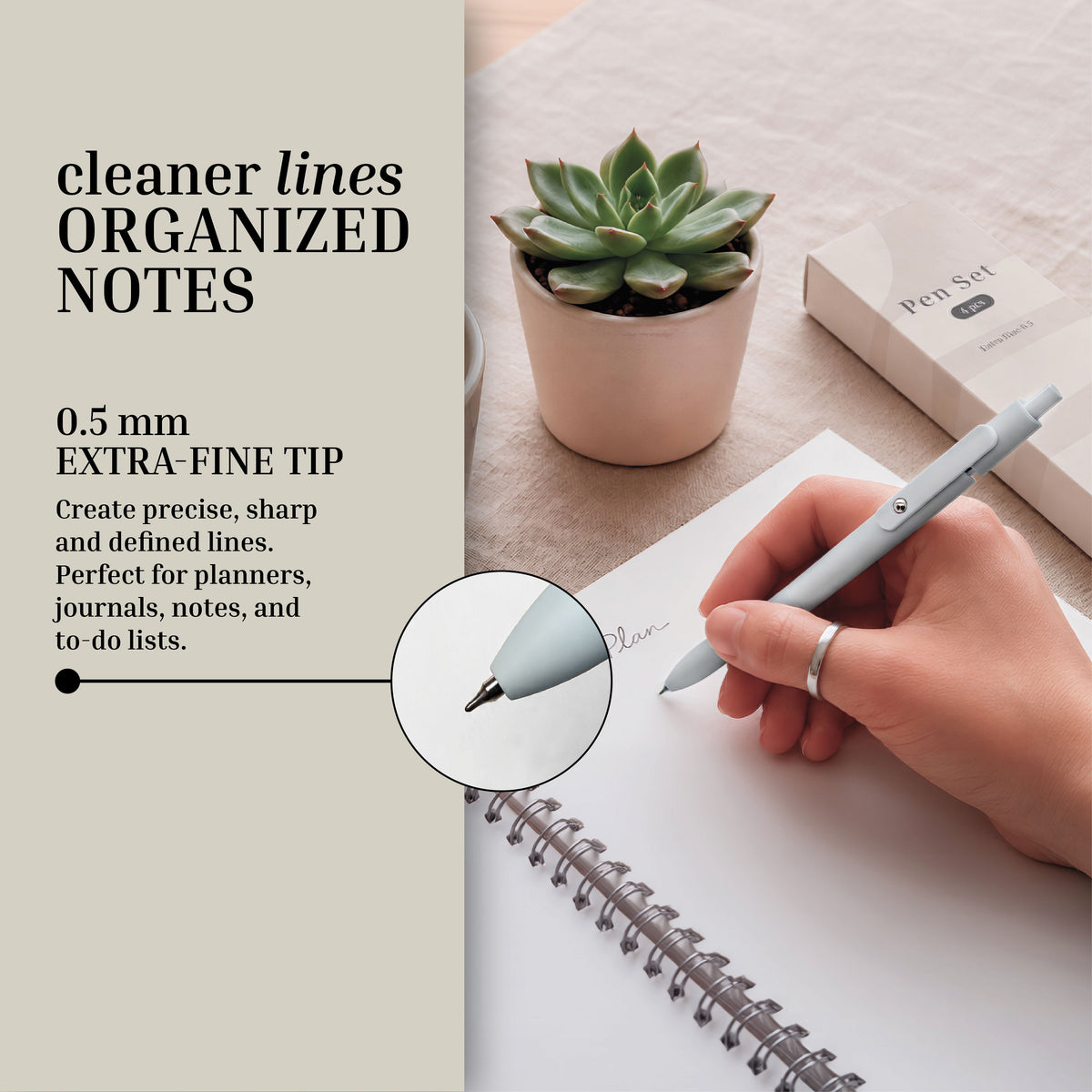 A hand writes in a spiral notebook with the Eterna Goods Extra Fine Ball Point Pen Set, featuring a 0.5mm extra-fine tip renowned for its smooth ink flow; a potted succulent and the branded pen set box rest on the desk. Text highlights the precision of Eterna Goods’ fine-tip pen for neat note-taking.