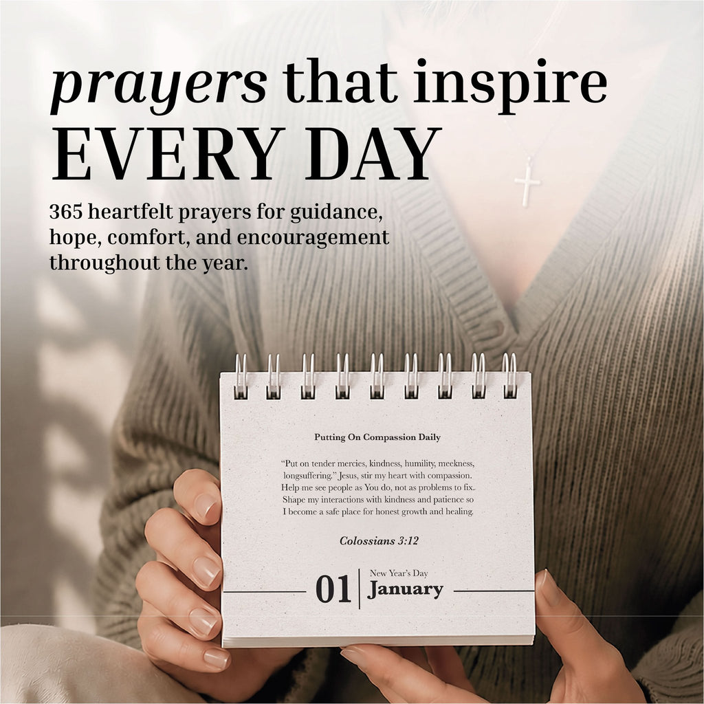 A person holds the Eterna Goods Perpetual Prayer A Day Calendar, a compact spiral-bound calendar featuring January 1, with a cross necklace in view and uplifting prayers from the calendar visible in the background.