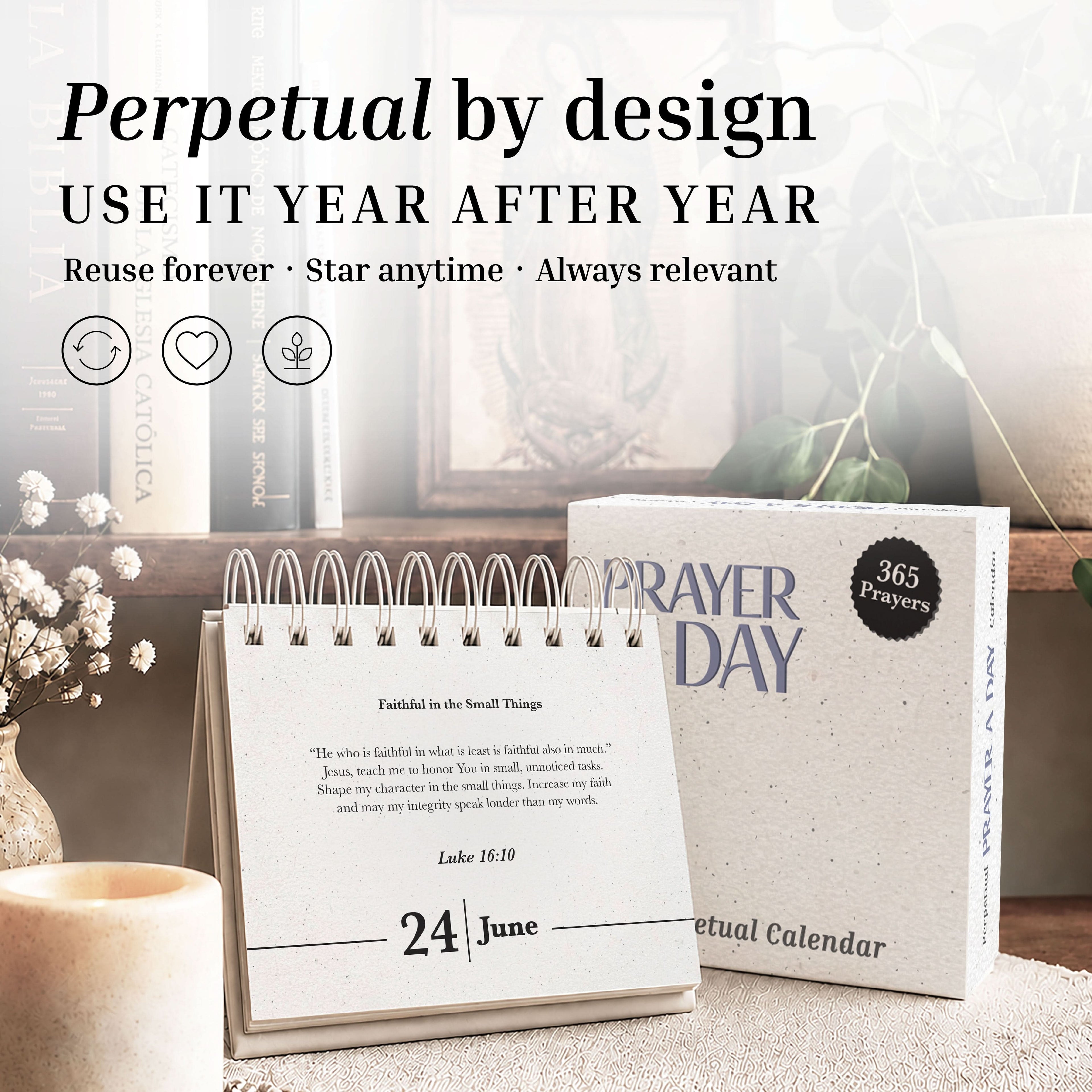 The Perpetual Prayer A Day Calendar by Eterna Goods sits on a desk, opened to June 24, displaying a scripture quote with daily inspirational prayers. The packaging box and decorative accents appear in the background.