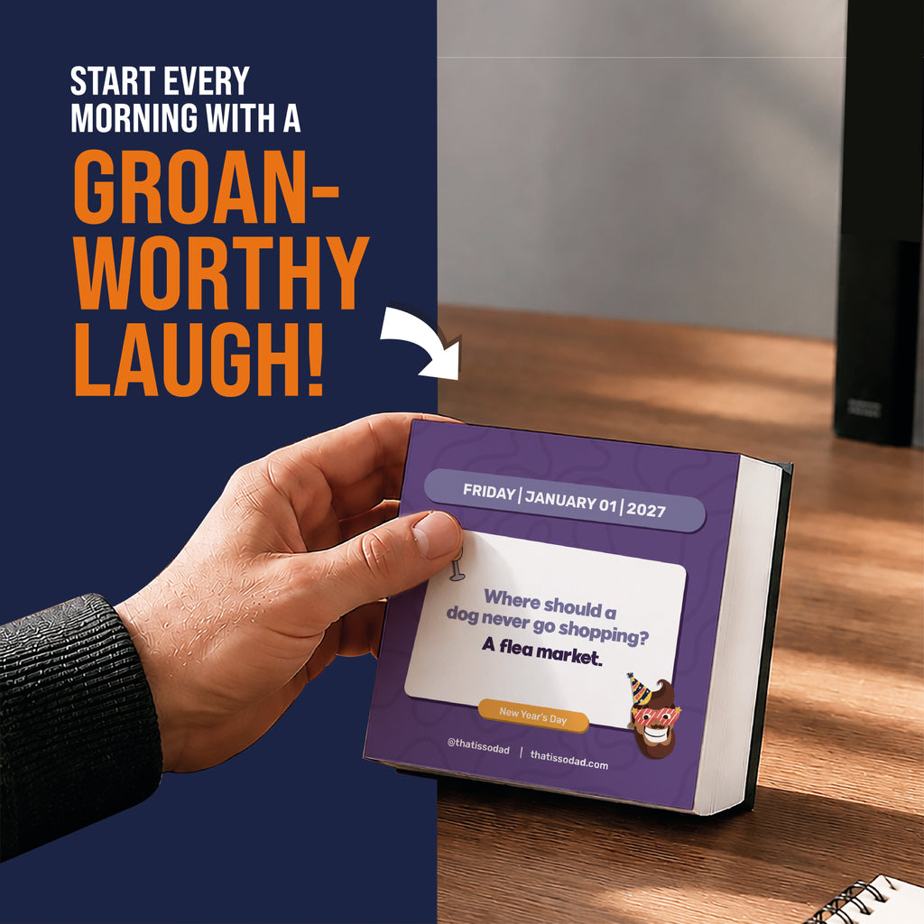 A hand holds the 2027 Daily Dad Joke Calendar from That Is So Dad, featuring a family-friendly classic: “Where should a dog never go shopping? A flea market.” Text above says, “Start every morning with a groan-worthy laugh!”.