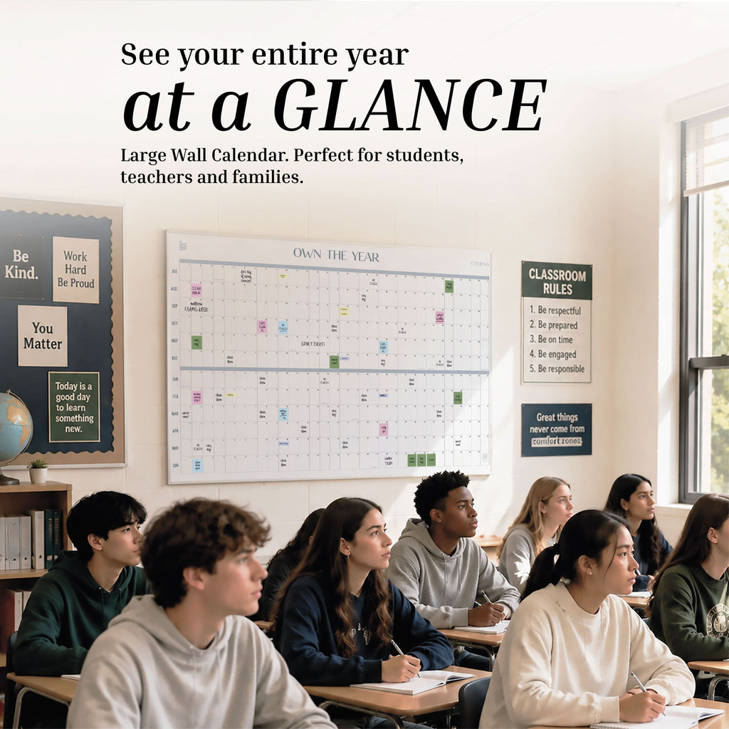 A diverse group of students sits at desks in a classroom, facing forward. An Eterna Goods Undated Midyear/Academic Own The Year Calendar hangs prominently on the wall alongside various motivational posters, helping to keep everyone organized and inspired throughout the academic year.