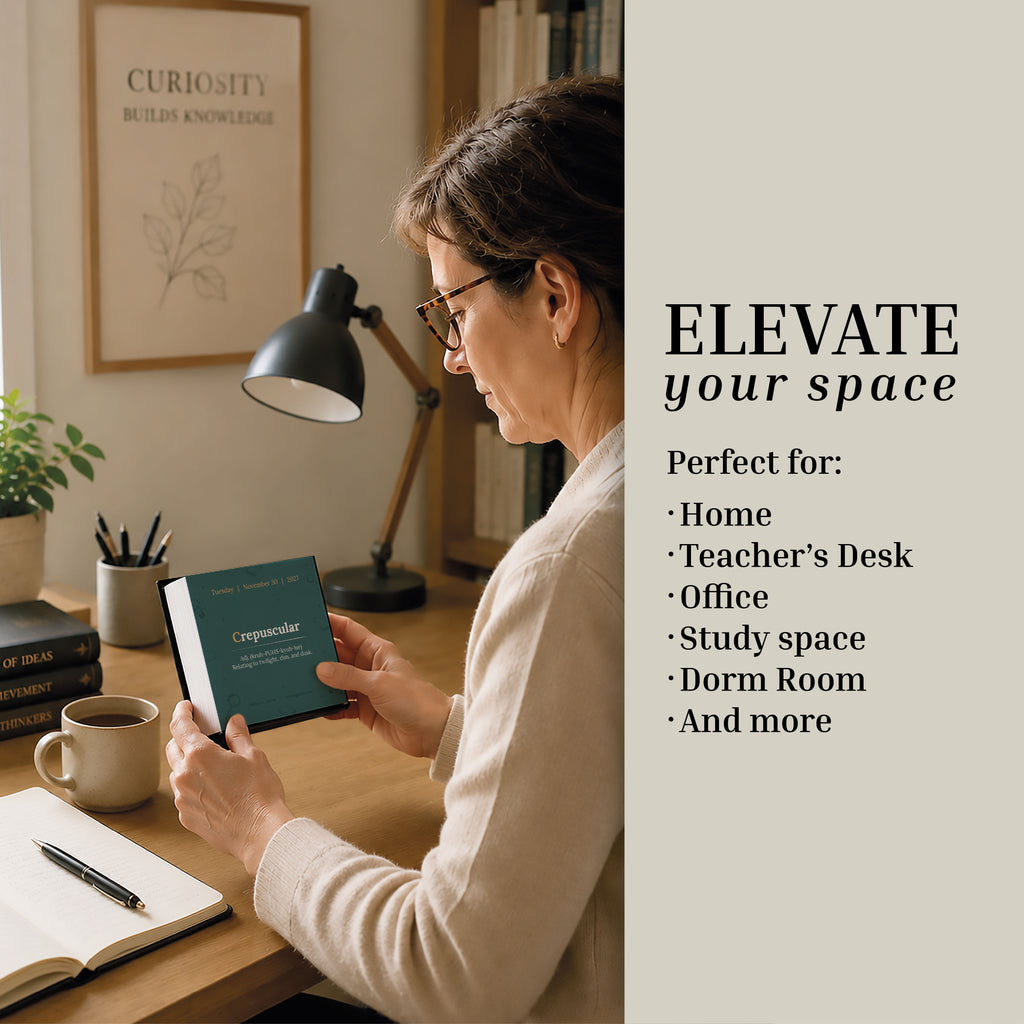 A woman sits at a desk, holding an inspiring framed quote, surrounded by books, a lamp, and a plant; let the featured message encourage you to elevate your home, office, or study space—brighten each area with thoughtful additions like the Eterna Goods 2027 Word Of The Day Calendar for daily vocabulary inspiration.