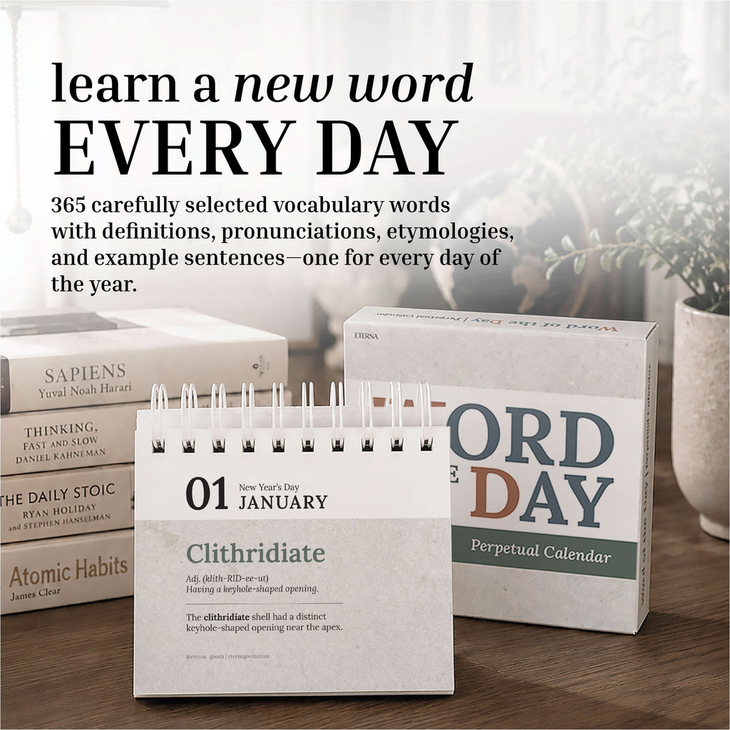 The Eterna Goods Perpetual Word of the Day Calendar sits atop a wooden surface with books stacked in the background, featuring "Clithridiate" and its definition for January 1 as a daily vocabulary builder.