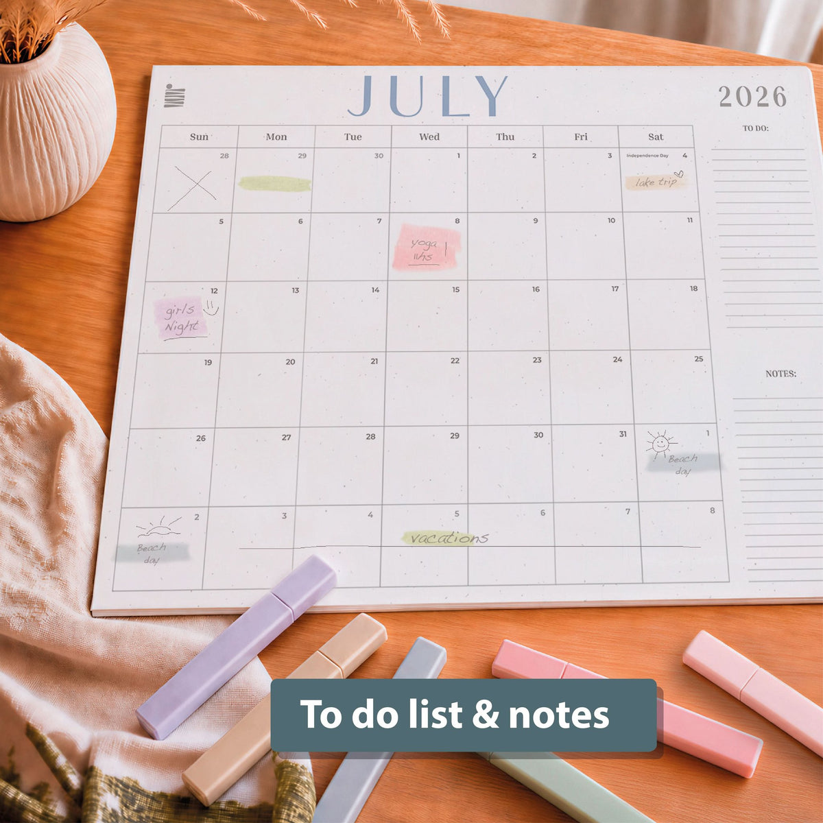 The Eterna Goods 2026-2027 18-Month Flat Desk Calendar (22"x17") lies on a wooden surface with large writing space, handwritten notes, and pastel highlighters; text overlay reads "To do list & notes.