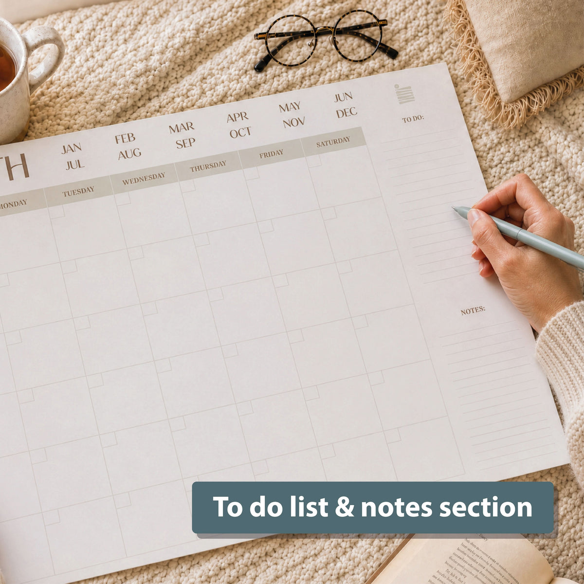 Writing on an Eterna monthly desk calendar beside a cup of coffee